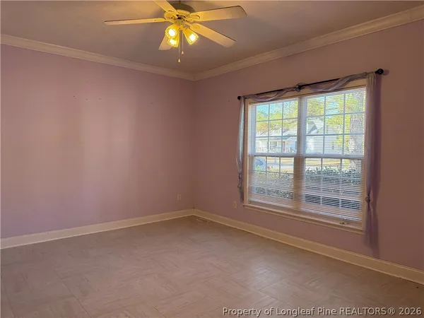 an empty room with a window and a fan