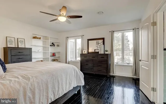 a kitchen with stainless steel appliances kitchen island granite countertop a refrigerator a sink dishwasher a stove and white cabinets with wooden floor