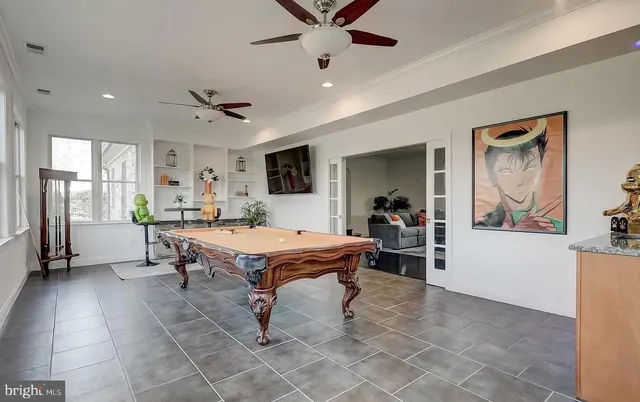 a kitchen with stainless steel appliances kitchen island granite countertop a refrigerator a sink dishwasher a stove and white cabinets with wooden floor