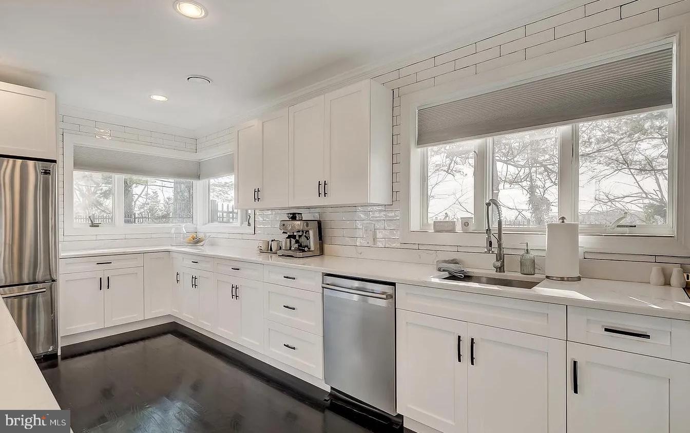 8040 Leishear Road Laurel, MD 20723 - Photo 46 of 66 a kitchen with white cabinets white appliances and sink