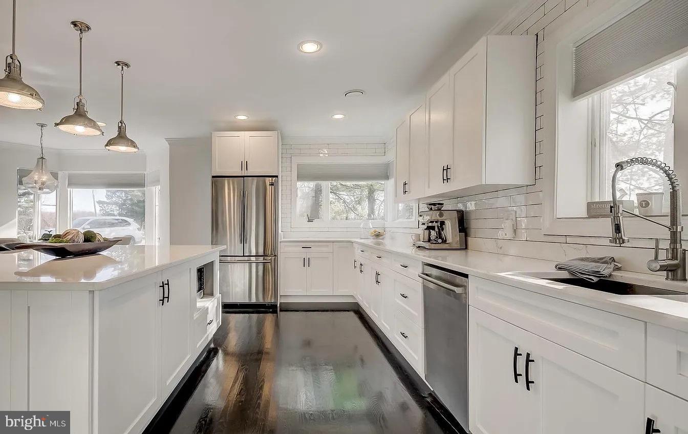 8040 Leishear Road Laurel, MD 20723 - Photo 48 of 66 a kitchen with stainless steel appliances kitchen island granite countertop a refrigerator a sink dishwasher a stove and white cabinets with wooden floor