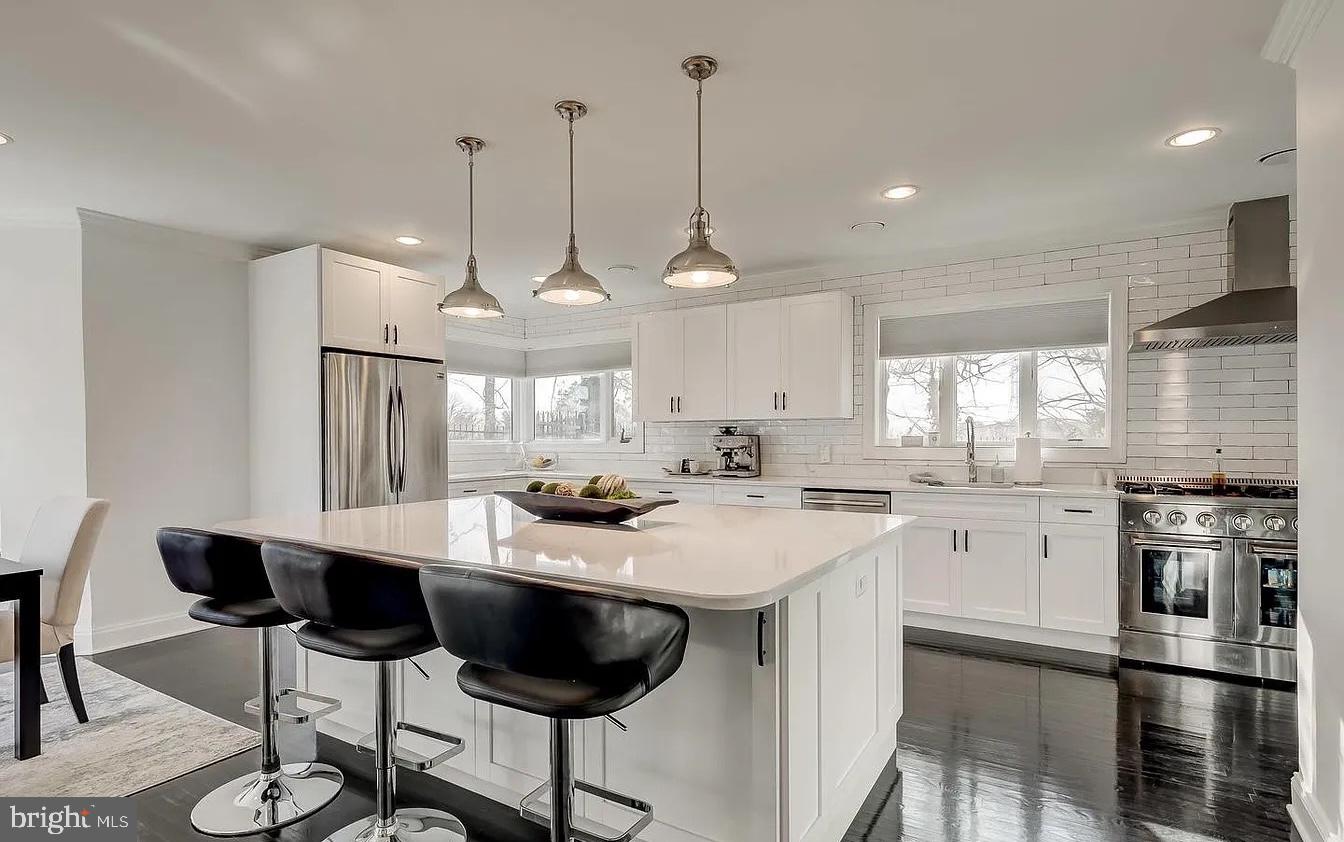 8040 Leishear Road Laurel, MD 20723 - Photo 53 of 66 a kitchen with stainless steel appliances kitchen island granite countertop a stove a sink a refrigerator a dining table and chairs with wooden floor