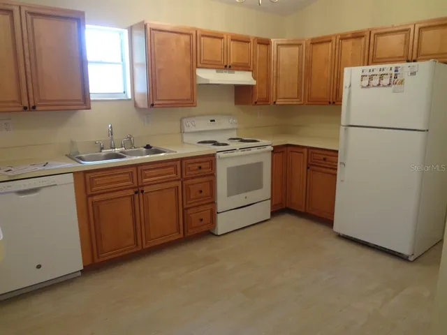 a kitchen with a sink a stove and refrigerator