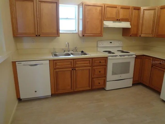 a kitchen with sink a stove and cabinets