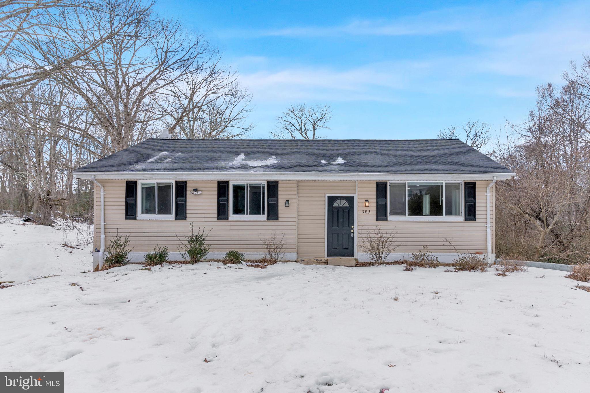 a front view of a house with a yard covered in snow