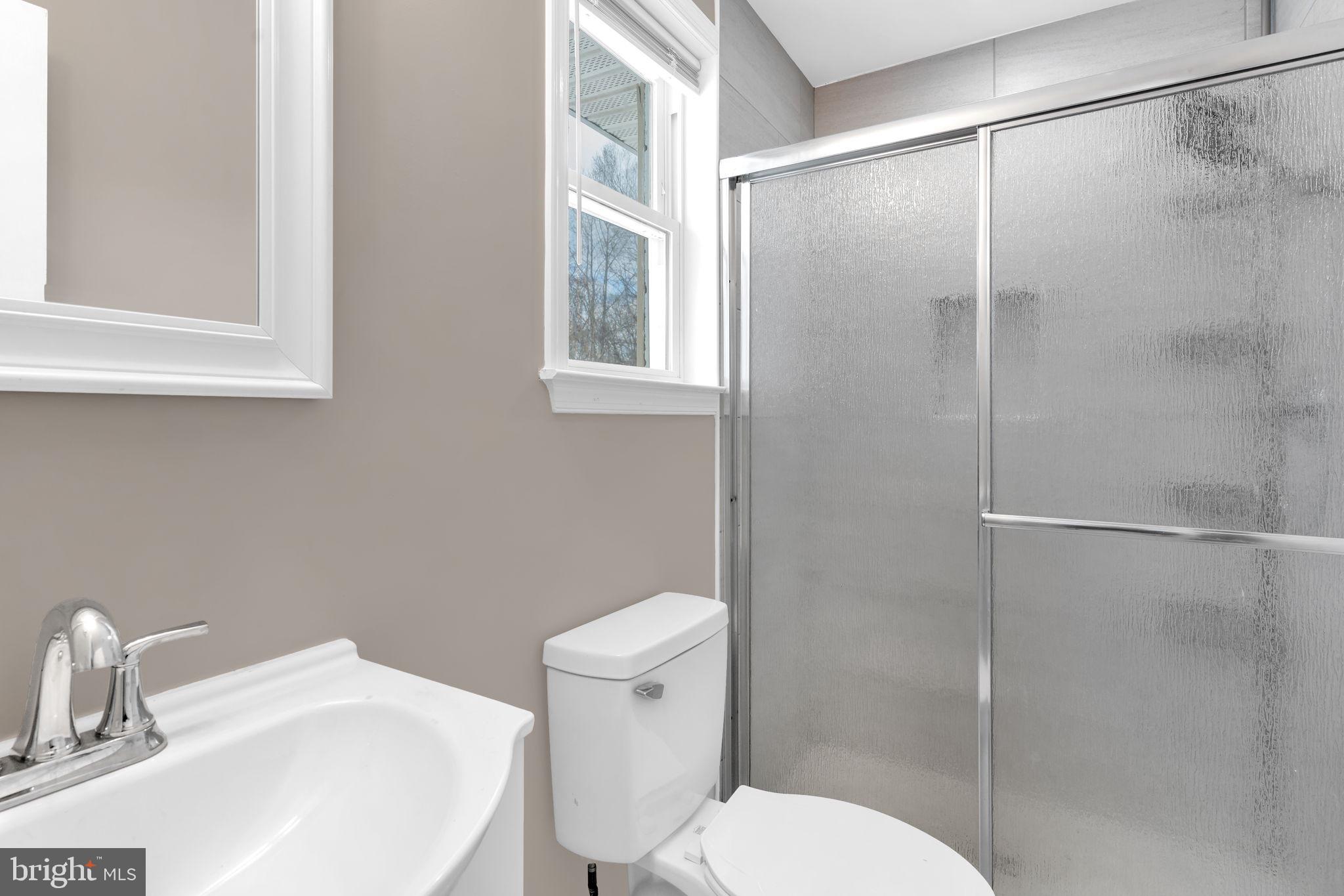 383 Sollers Wharf Road, Unit A Lusby, MD 20657 - Photo 11 of 16 a white toilet sitting next to a bathroom sink