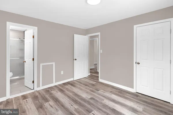a view of a room with wooden floor and a bathroom