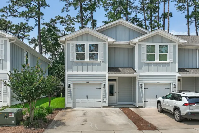 an aerial view of residential houses with outdoor space and trees