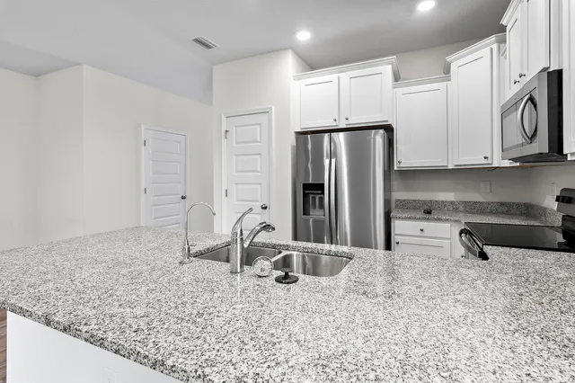 a kitchen with stainless steel appliances granite countertop a stove and a sink