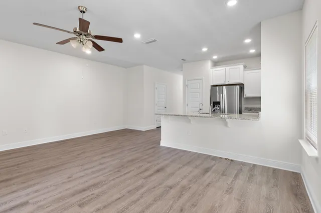 a kitchen with stainless steel appliances granite countertop a refrigerator and a stove top oven