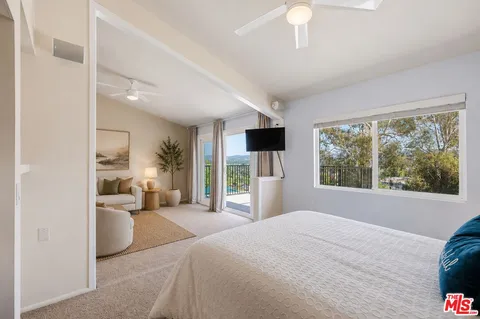 a bedroom with a large bed and a large window