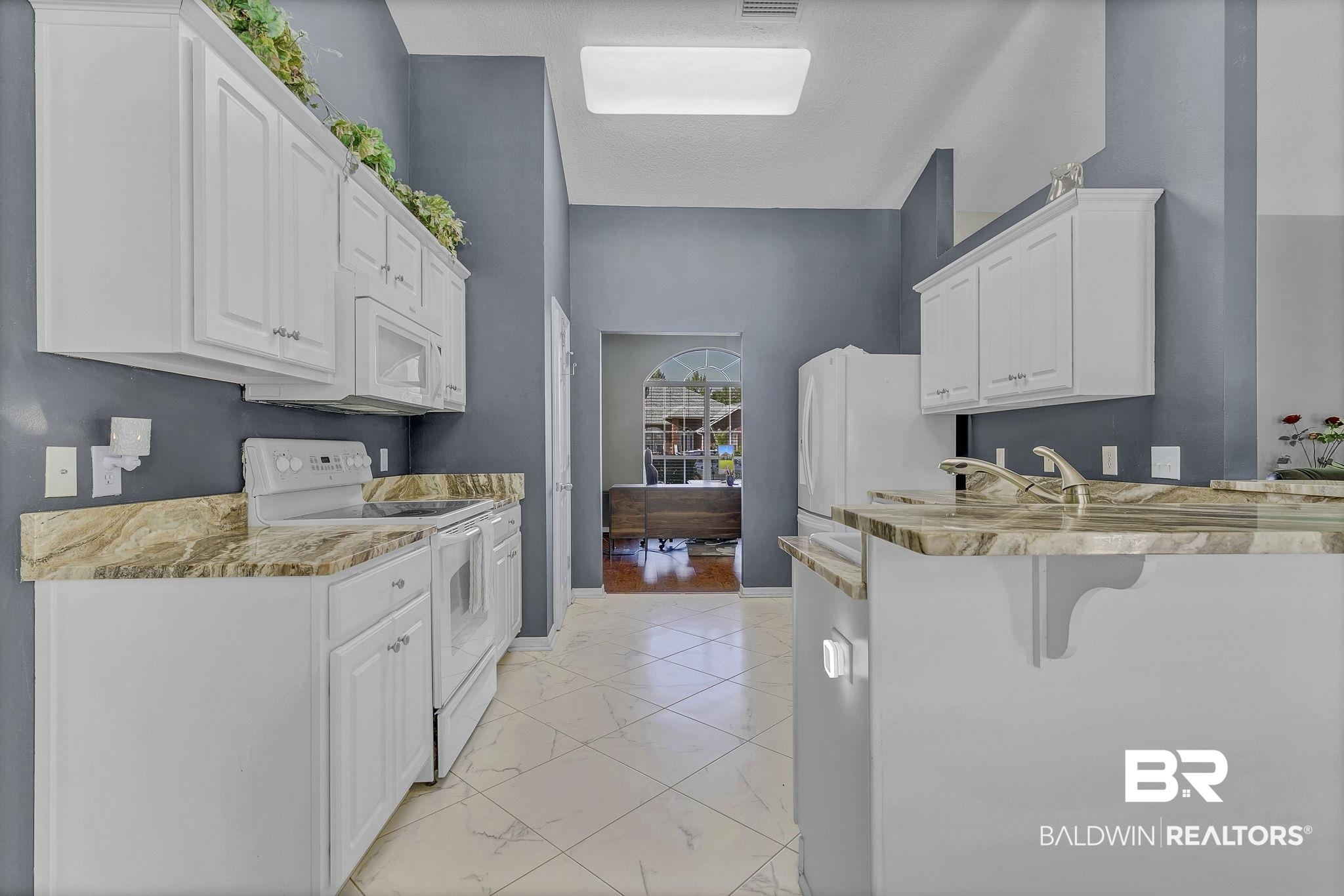 16358 Tempest Drive Foley, AL 36535 - Photo 12 of 46 Kitchen with white cabinets, marble finish floor, a breakfast bar, and white appliances
