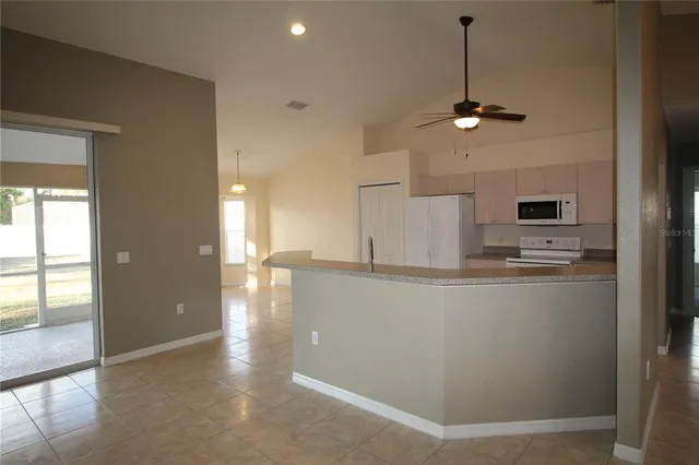 a view of a kitchen with refrigerator and windows