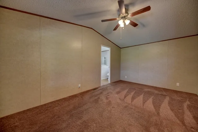 an empty room with a ceiling fan and a window