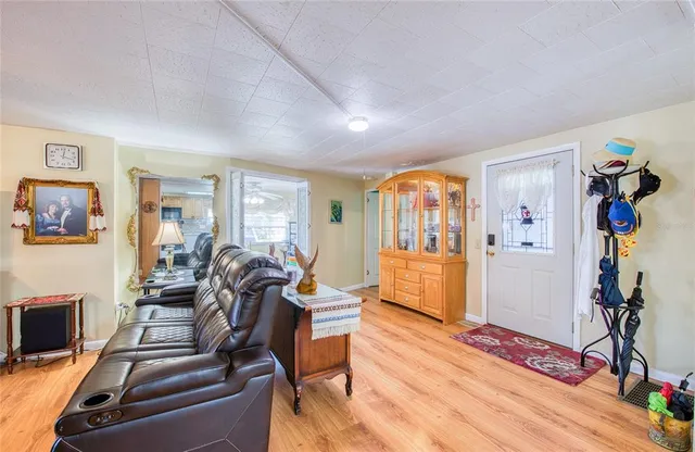 a living room with furniture a wooden floor and next to a window