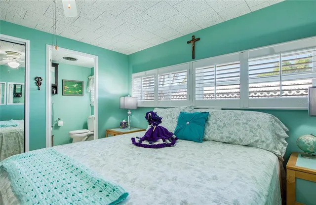 a bedroom with a bed and large windows