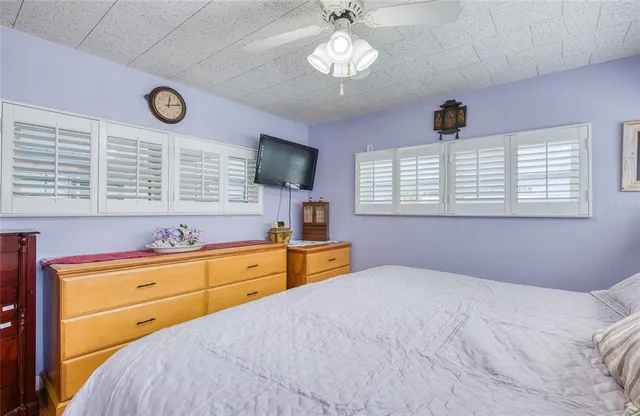 a bedroom with a large bed and a flat tv screen on dresser
