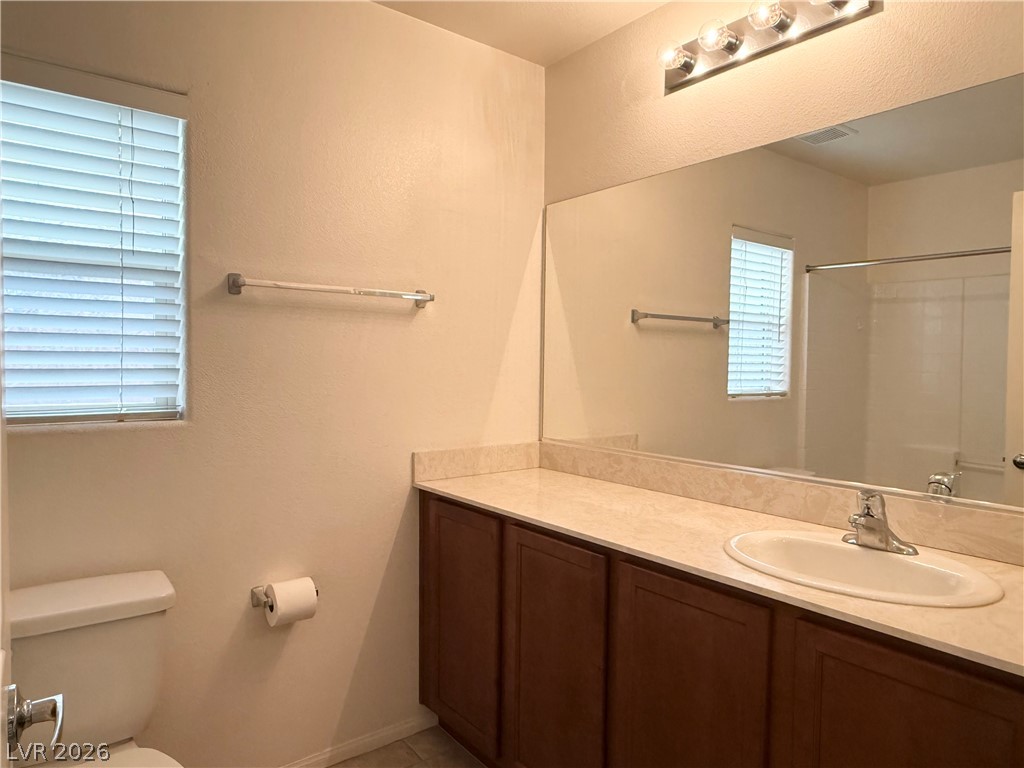 8231 Buffalo Ranch Avenue Las Vegas, NV 89147 - Photo 18 of 22 A well-appointed bath features a spacious vanity with an integrated sink and an illuminated mirror.