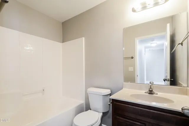 a bathroom with a sink toilet vanity and tub