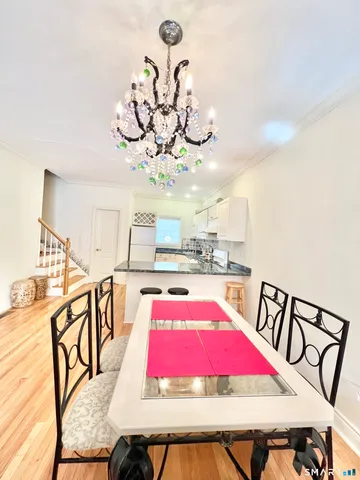 a view of a dining room with furniture a chandelier and wooden floor