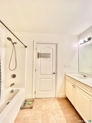 a bathroom with a tub a sink and a shower