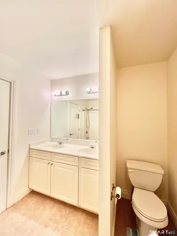 a bathroom with a granite countertop toilet sink and mirror