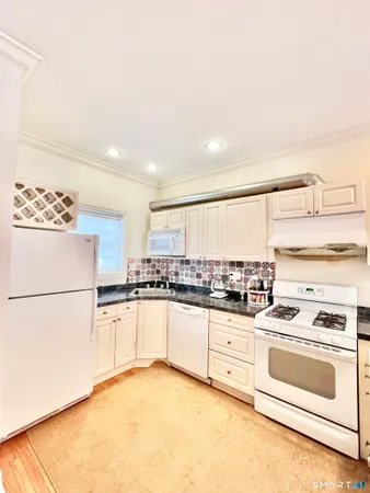a kitchen with white cabinets and white appliances