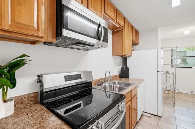 a kitchen with stainless steel appliances granite countertop a stove a washer and dryer