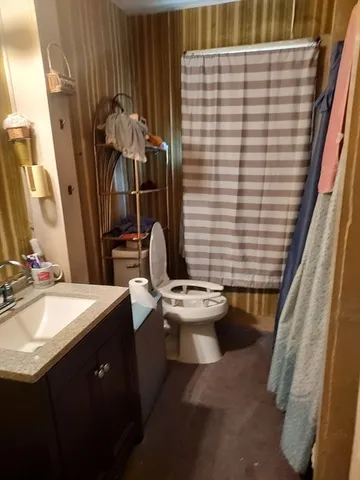 a bathroom with a sink toilet and shower