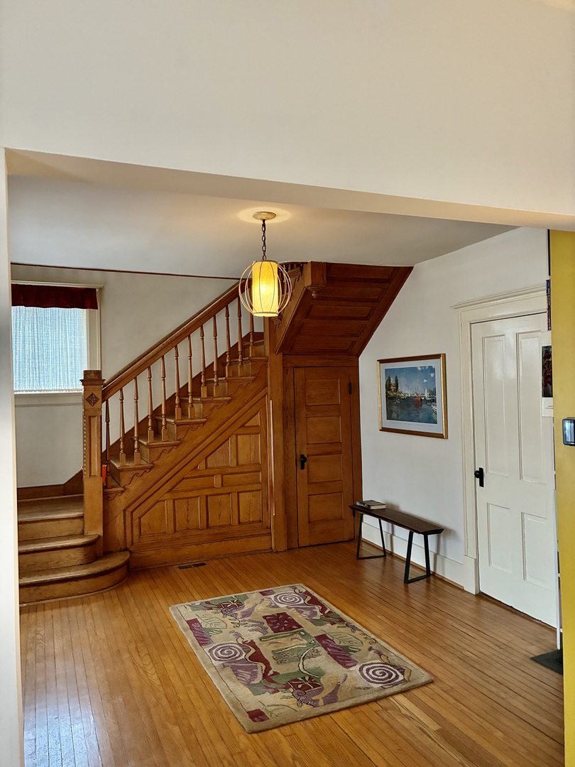 1009 West Church Street Champaign, IL 61821 - Photo 3 of 40 a view of a livingroom with wooden floor and a stairs