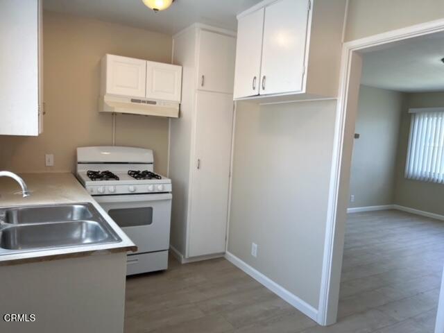 714 West 5th Street, Unit 714D Oxnard, CA 93030 - Photo 3 of 7 a kitchen with granite countertop a sink and a stove top oven