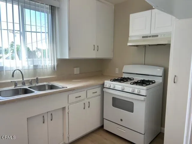 a kitchen with cabinets appliances a sink and a window