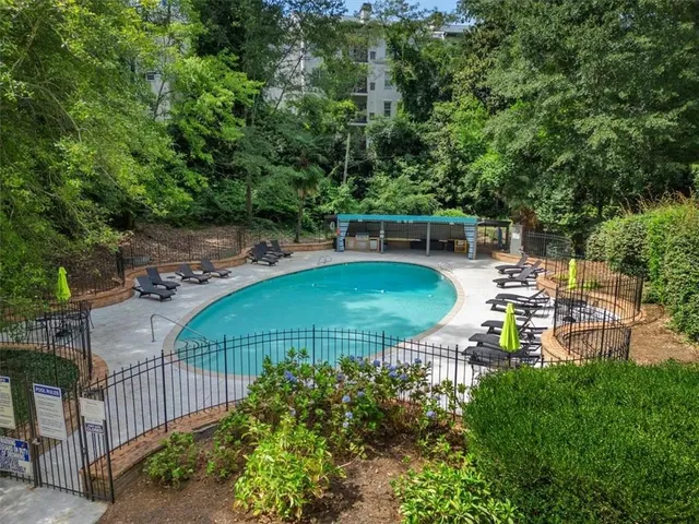 a view of a swimming pool with a patio and a garden
