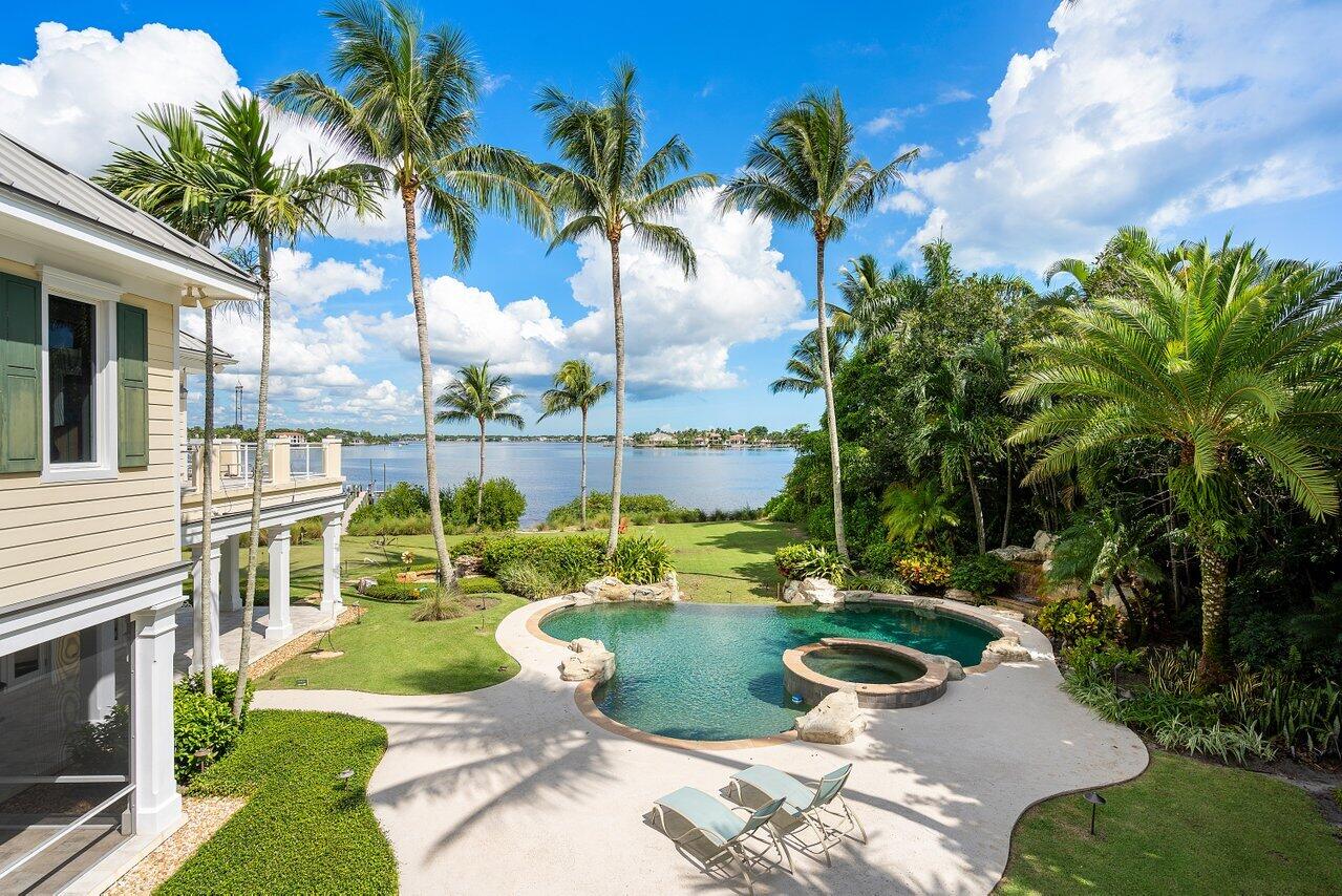 5559 Pennock Point Road Jupiter, FL 33458 - Photo 38 of 72 a swimming pool with plants and palm trees