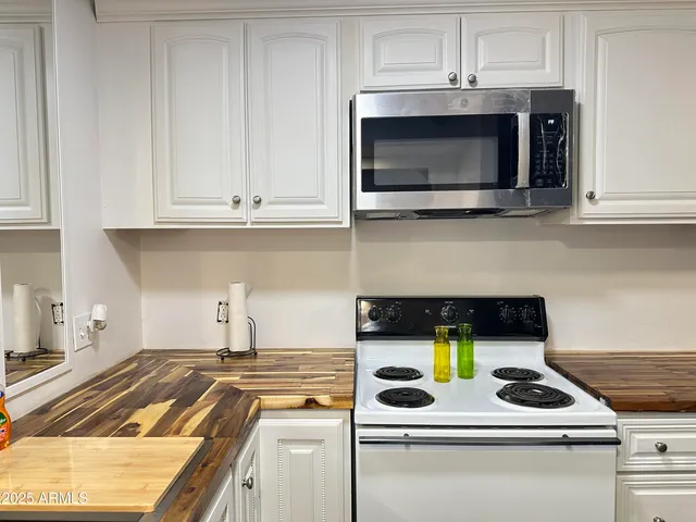 a kitchen with a stove and a white cabinets
