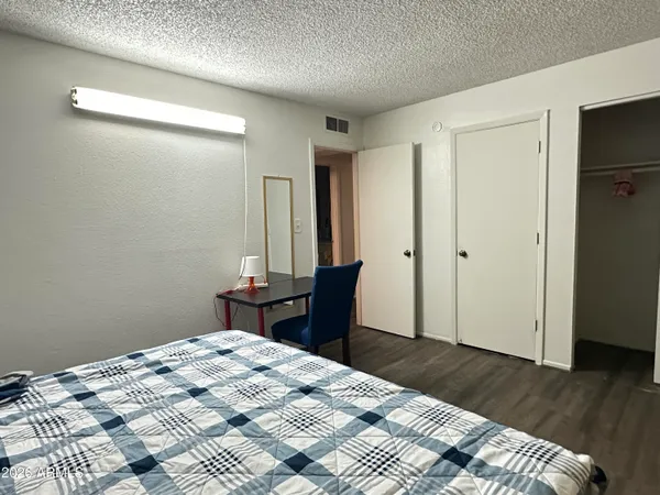 a bedroom with a bed and wooden floor