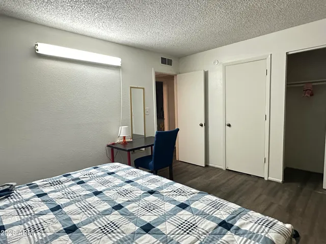 a bedroom with a bed and wooden floor