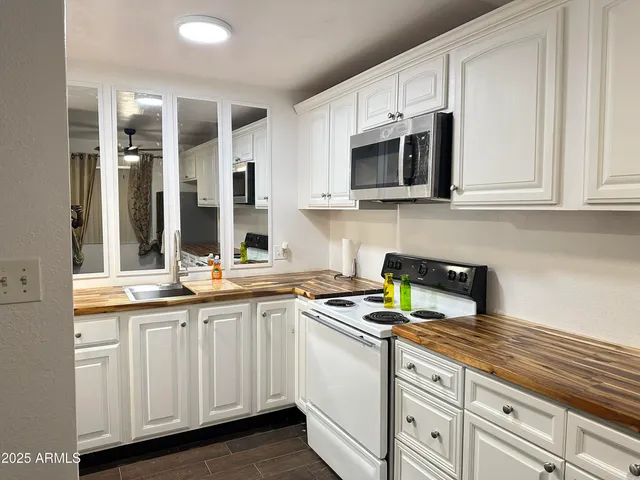 a kitchen with white cabinets and appliances