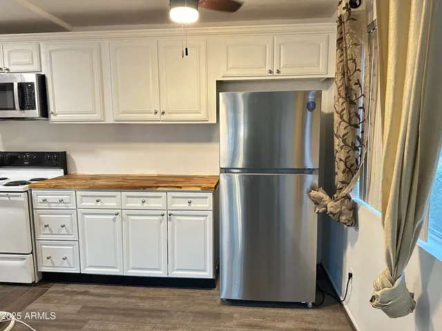 a kitchen with stainless steel appliances white cabinets and a refrigerator