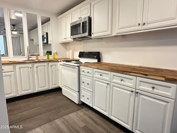 a kitchen with stainless steel appliances granite countertop white cabinets a sink and dishwasher