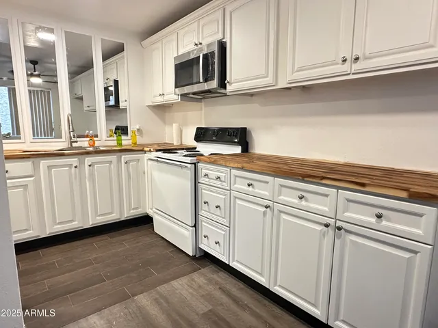 a kitchen with stainless steel appliances granite countertop white cabinets a sink and dishwasher