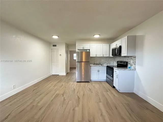a kitchen with a refrigerator and a stove top oven