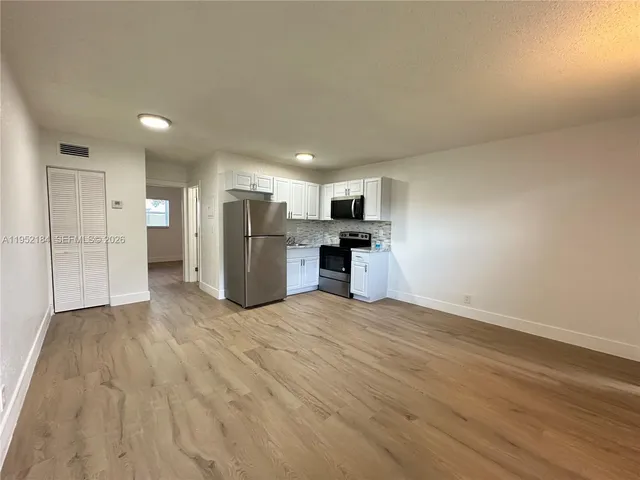 a view of a kitchen with a sink and a refrigerator