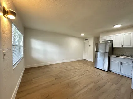 a view of a kitchen with a sink and a refrigerator
