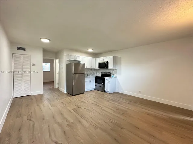 a view of kitchen with refrigerator and wooden floor