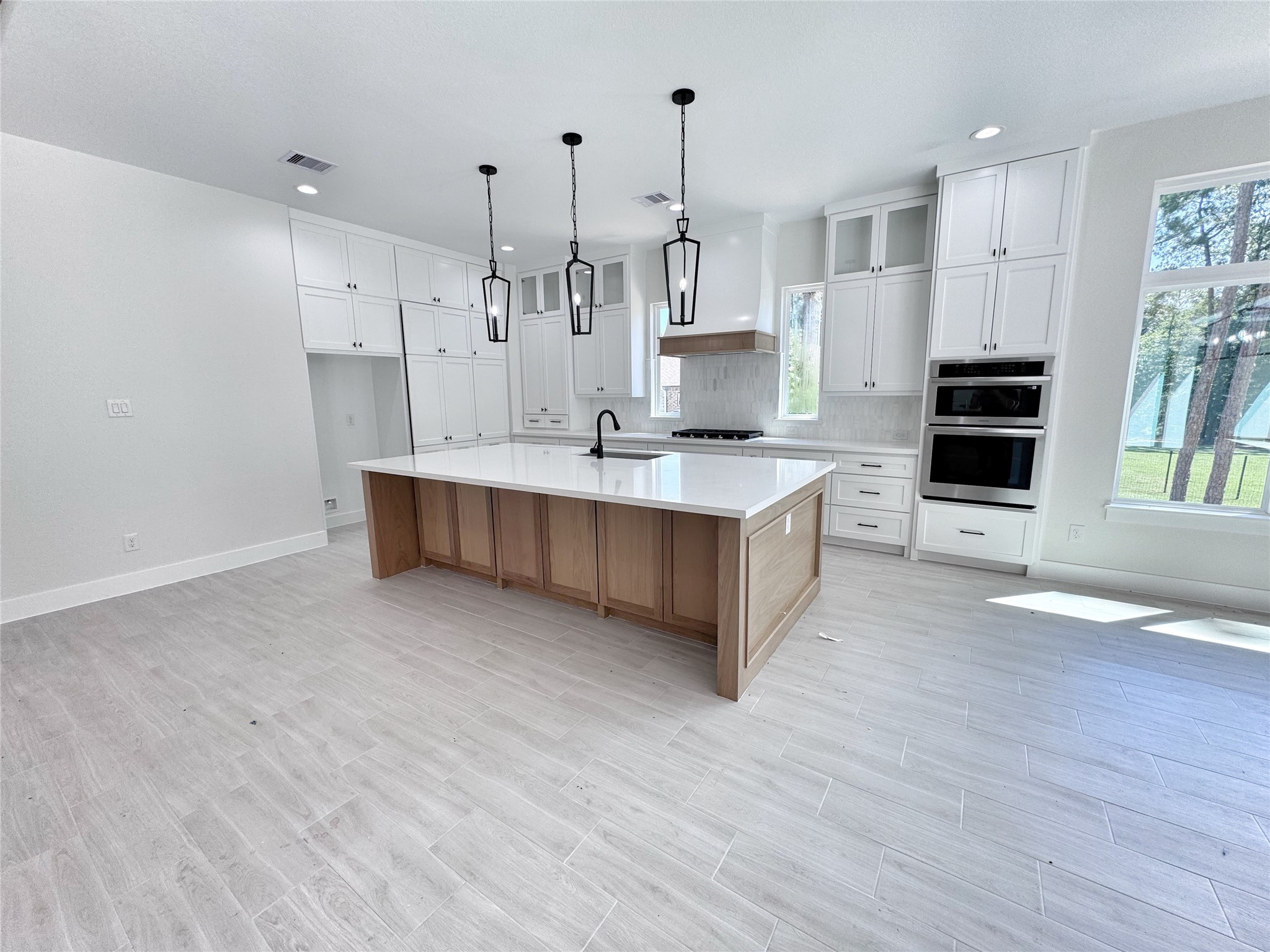 27710 Colapis Drive Splendora, TX 77372 - Photo 15 of 49 a large kitchen with stainless steel appliances kitchen island granite countertop a large counter top and wooden floors