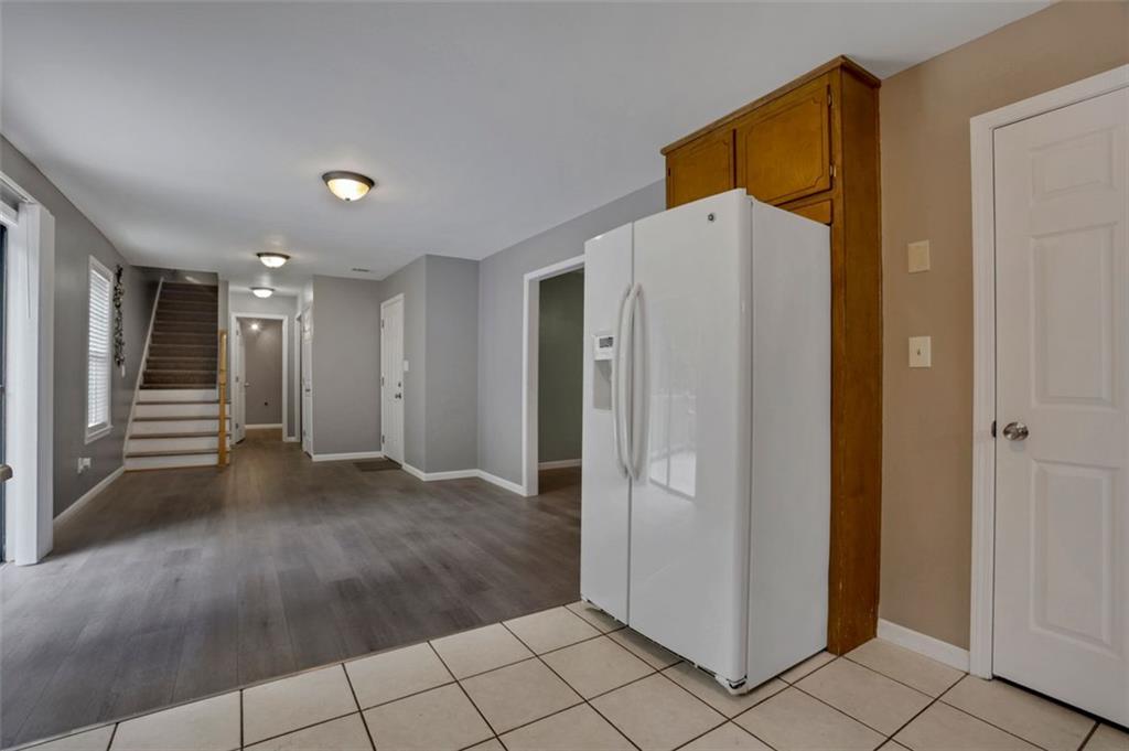 4378 Ridge Court Loganville, GA 30052 - Photo 11 of 47 a view of a refrigerator in kitchen and an empty room