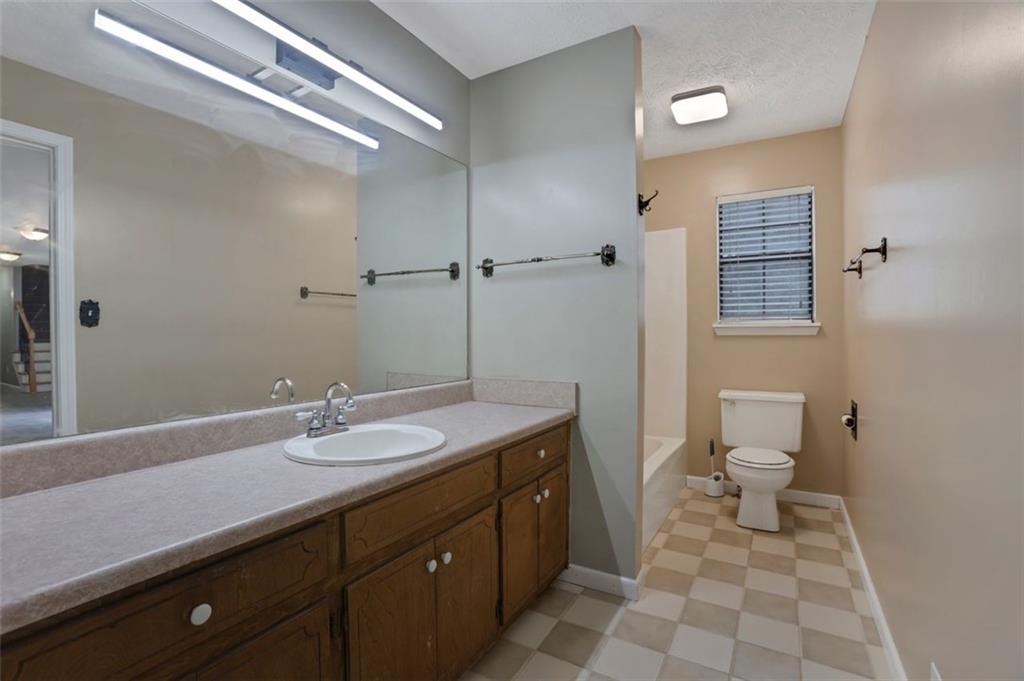4378 Ridge Court Loganville, GA 30052 - Photo 19 of 47 a bathroom with a sink a toilet and a mirror