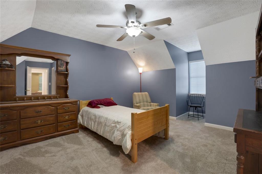 4378 Ridge Court Loganville, GA 30052 - Photo 21 of 47 a bedroom with a bed and a chandelier