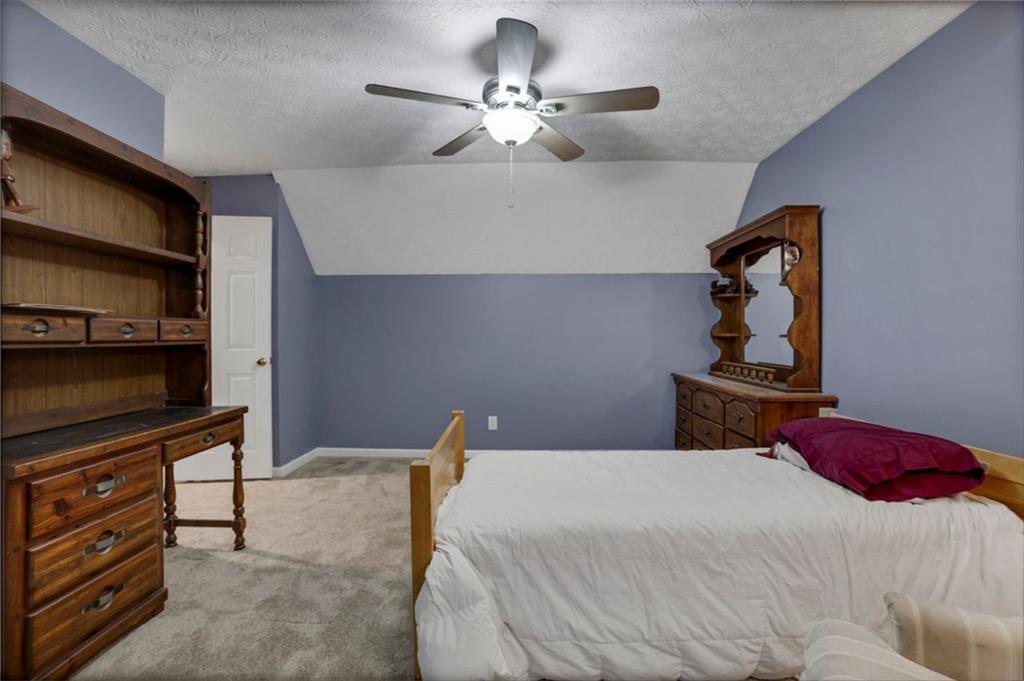 4378 Ridge Court Loganville, GA 30052 - Photo 22 of 47 a bedroom with a bed and a chandelier